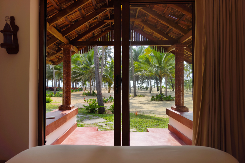 Exterior of a beautiful, traditional Kerala heritage home with tiled roof and lush green garden